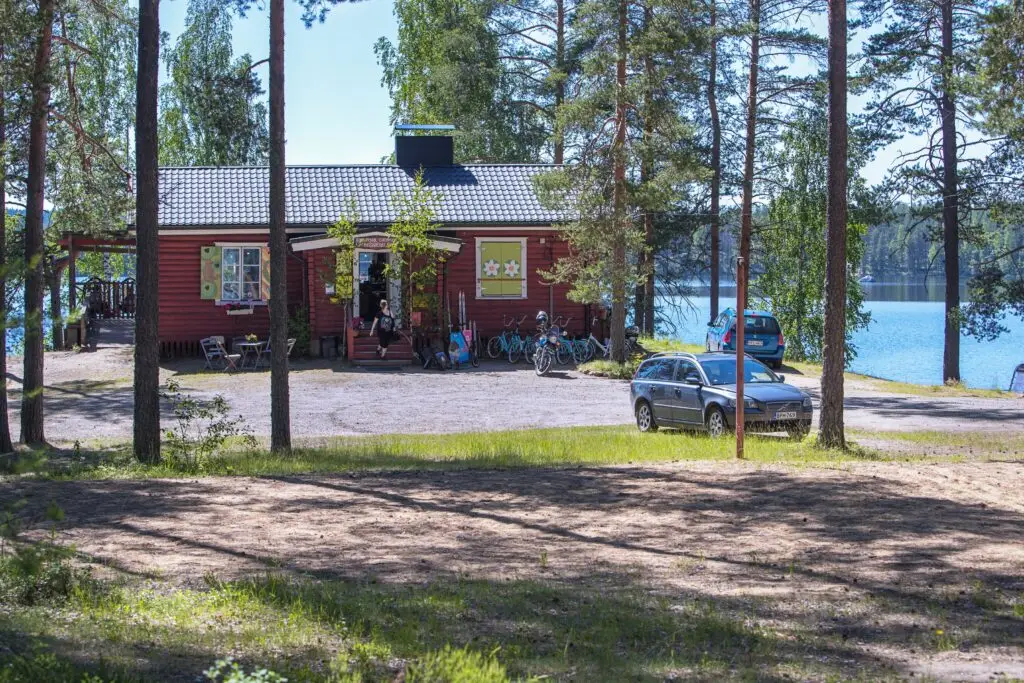kahvila, autoja parkkipaikalla, juhannuskoivut, järvi
