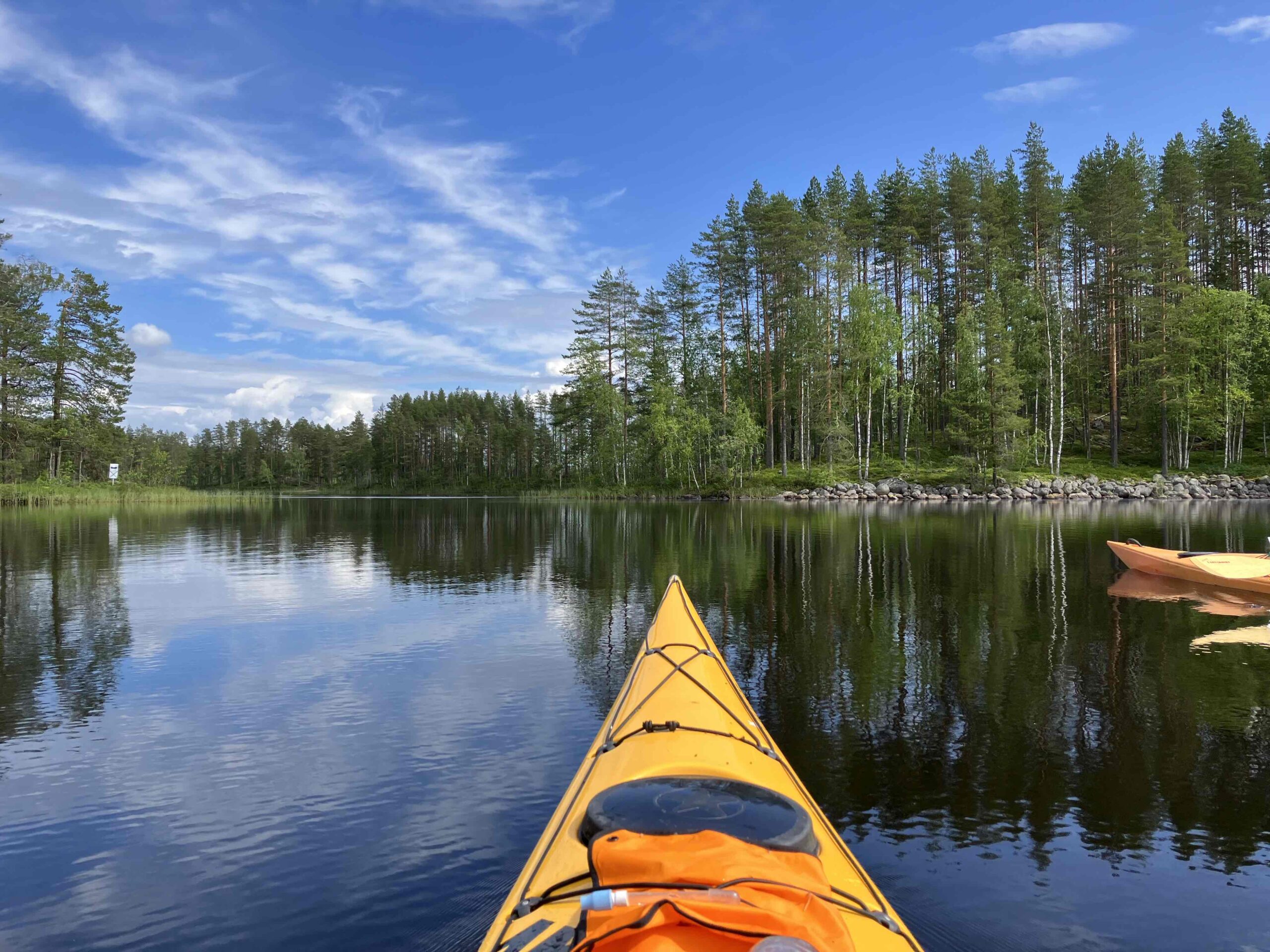 kajakkeja järvellä taustalla metsää ja taivasta
